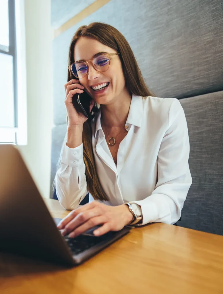 Cheffe d’entreprise au téléphone devant son ordinateur portable